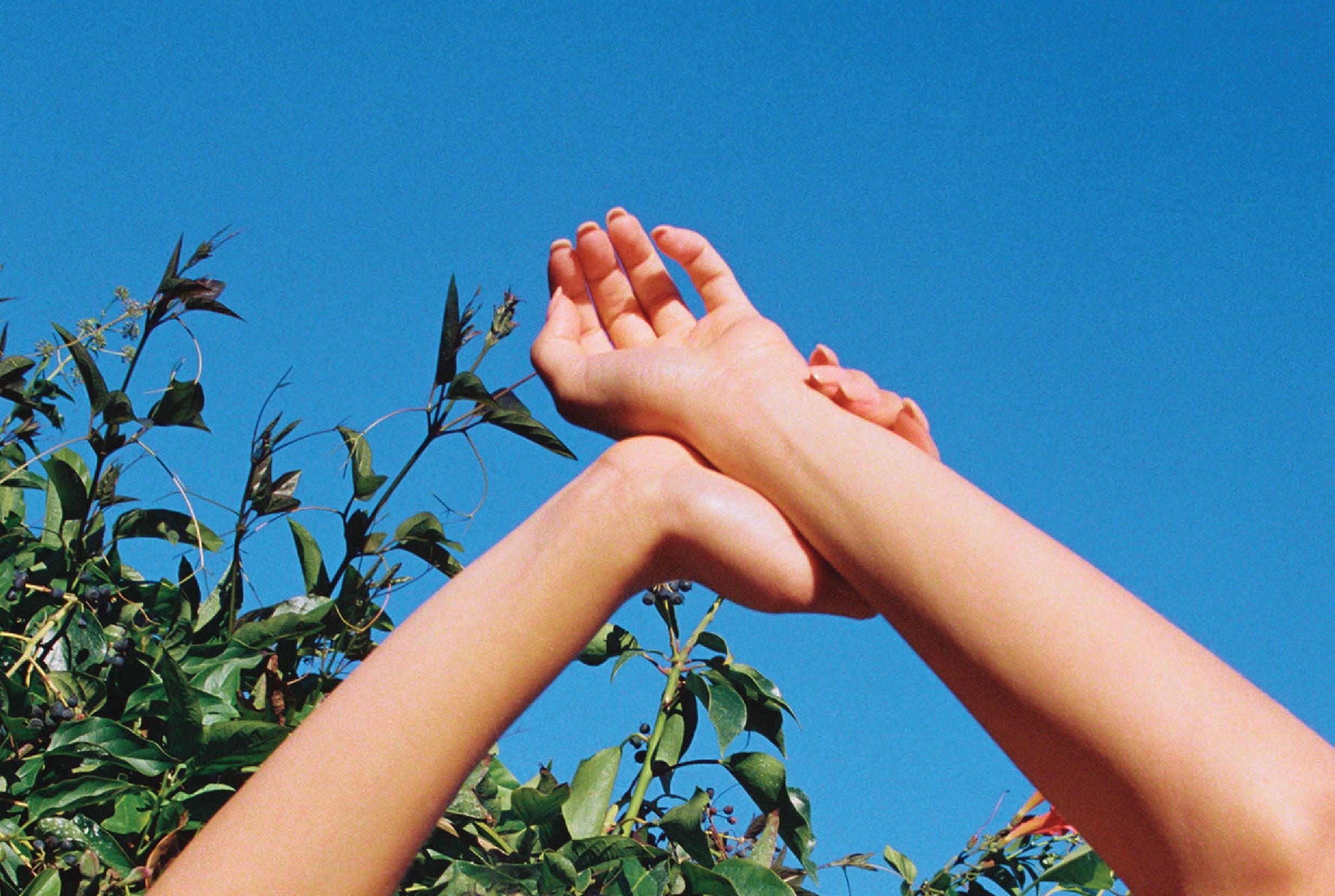 woman's hands reaching into the air